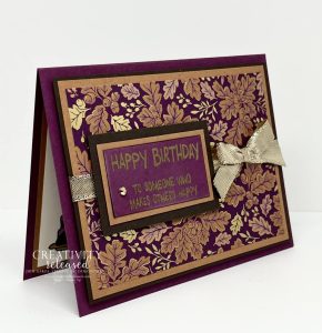 A side view of a birthday card using DSP with the colors found in the CCMC 692 Thursday Challenge, using all Stampin' Up! products. A pop of shiny gold ribbon and a gilded gem accent the card.