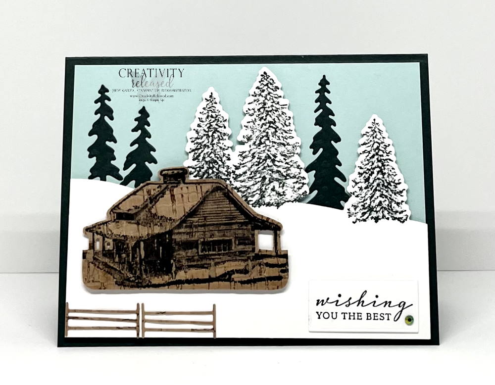 A wintery scene with a cabin and tall pine trees on a snowy hill sending best wishes. Stampin' Up!'s Peaceful Cabin bundle is used.