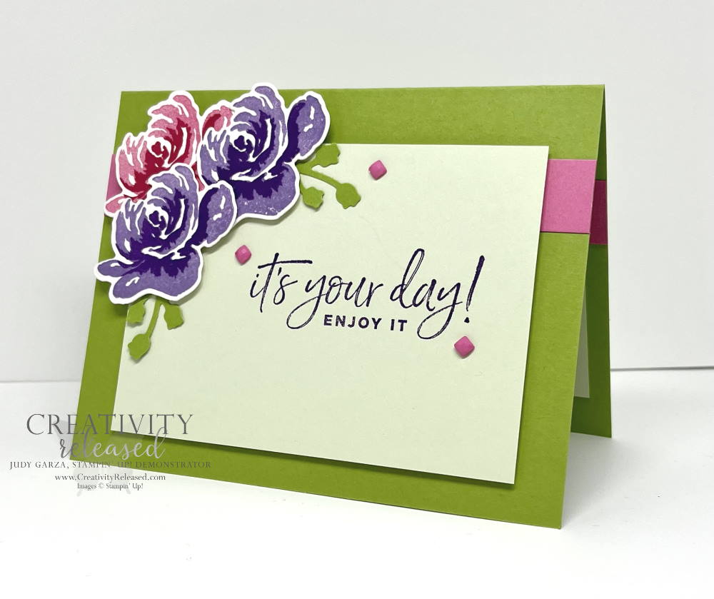 Side view of a birthday card using bright green, two shades of purple and two shades of pink on three flowers in the upper left corner. Stamps by Stampin' Up!