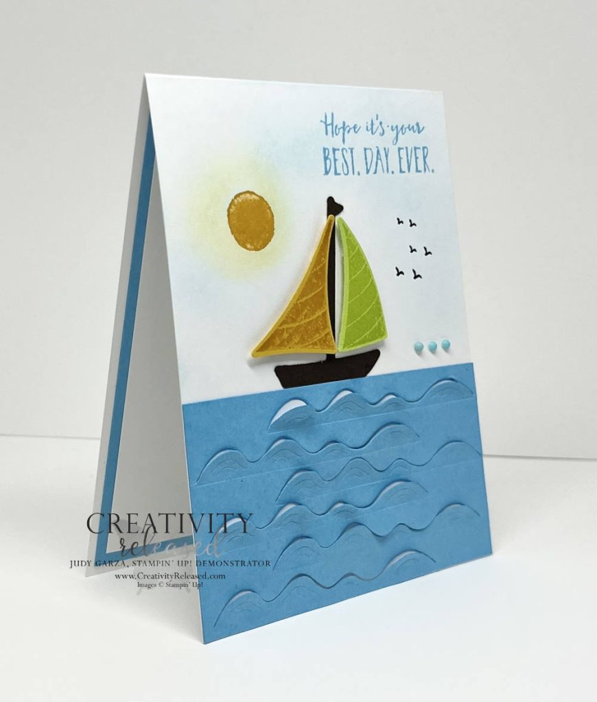 Side view of a "Best Day Ever" greeting card with Tahitian Tide 'water', and a sail boat sailing under the sun and some birds flying overhead.