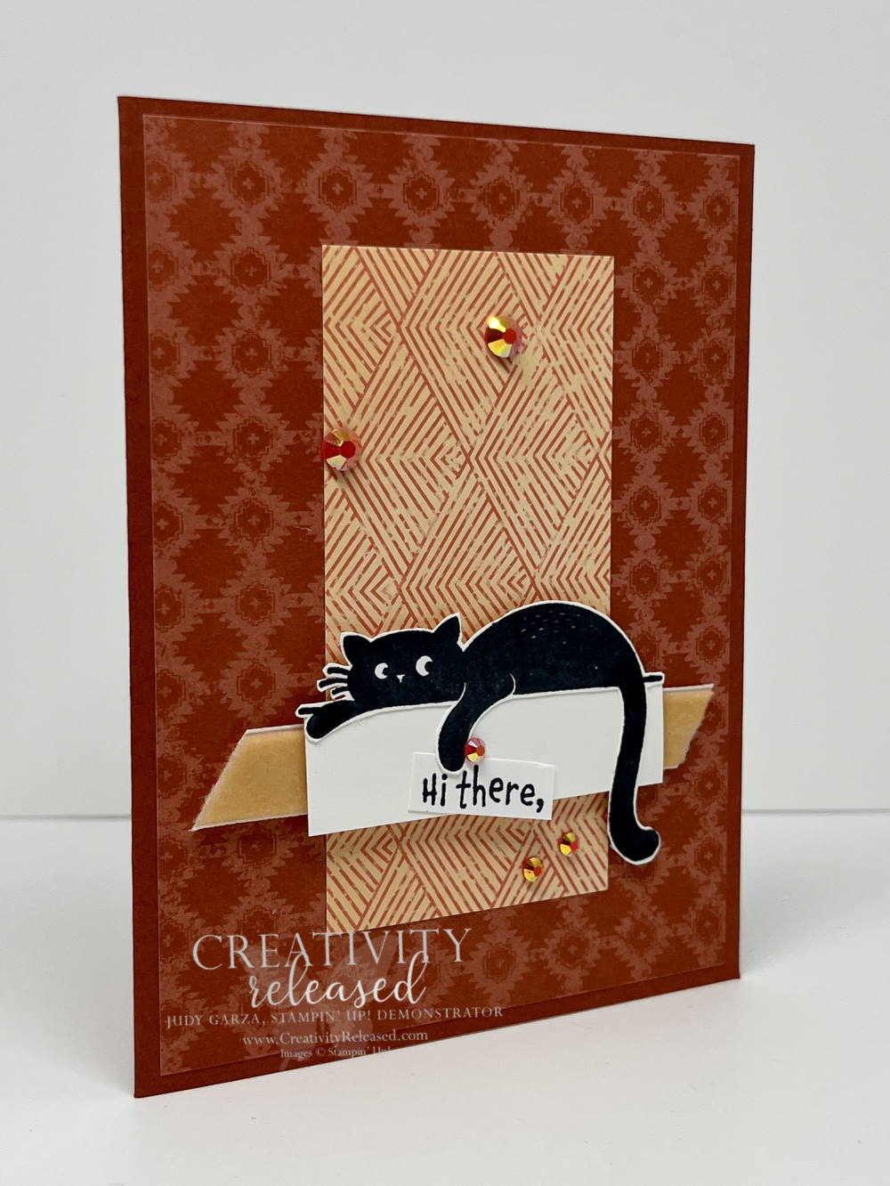 Side view of a "Herllo" card featuring a black cat lying on a shelf holding a sign that says "Hi There"